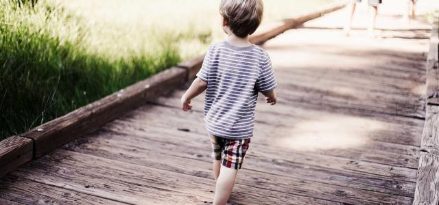 Child running on wooden bridge.